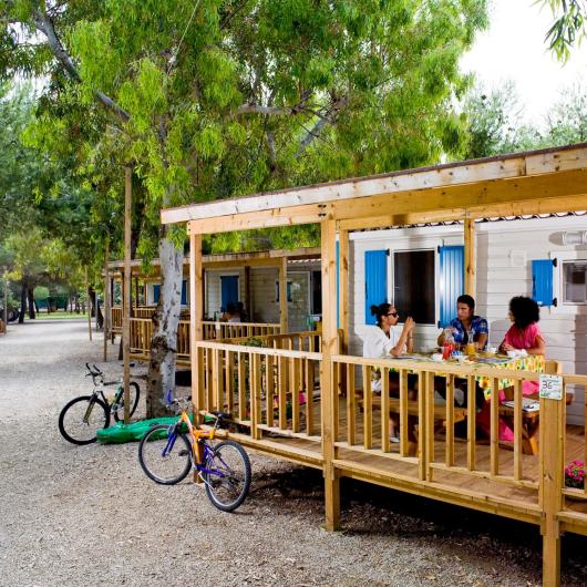 Persone sedute su una veranda di legno in un campeggio.