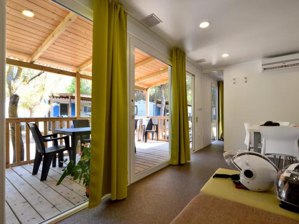 Intérieur moderne avec balcon, table à manger et casques de moto.