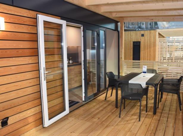 Terrazza moderna in legno con tavolo e sedie.