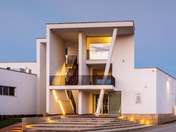 Edificio moderno con illuminazione esterna e design geometrico.