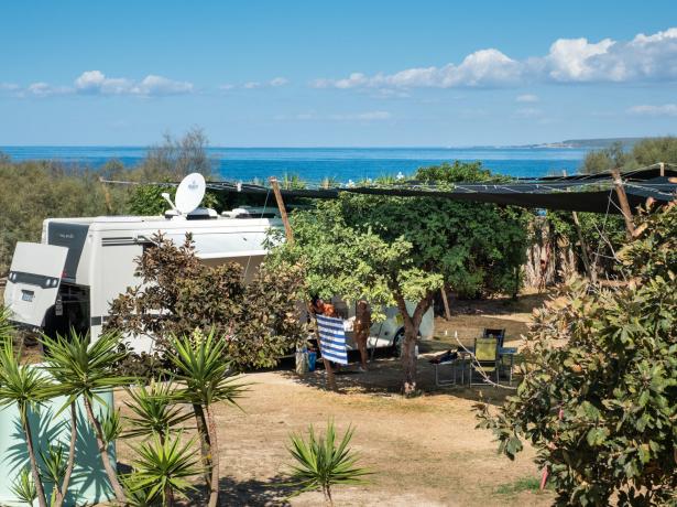 Camper parcheggiato vicino al mare con vista panoramica.