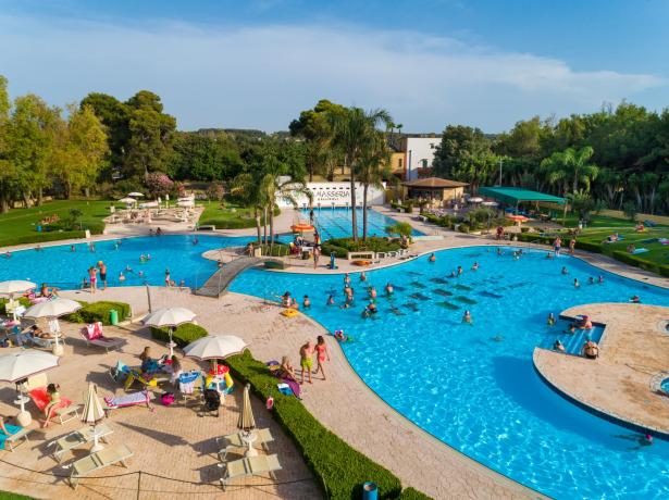Piscina all'aperto con persone che si rilassano e nuotano.