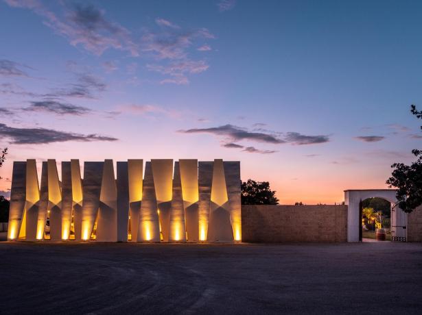 Struttura moderna illuminata al tramonto con un arco d'ingresso.