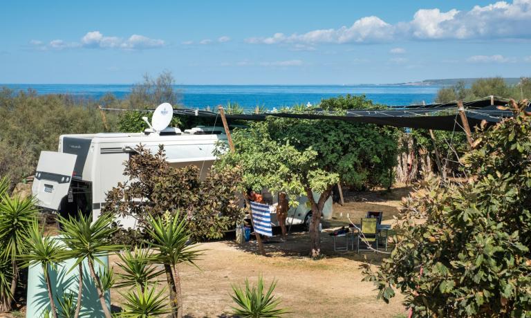 Camper parcheggiato vicino al mare con vista panoramica.