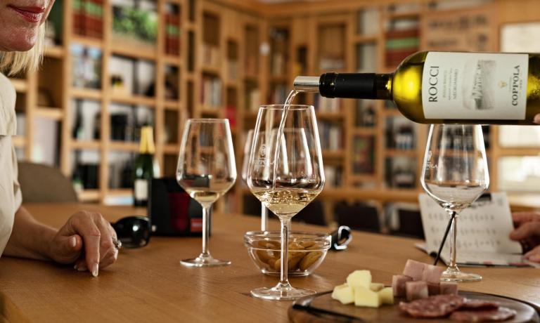 Degustazione di vino bianco con formaggi e salumi.