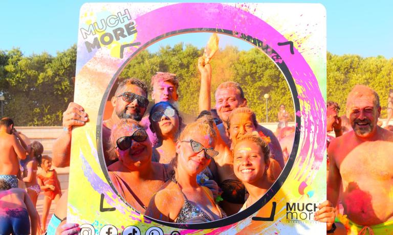 Glückliche Gruppe bei einem bunten Event mit Much More Rahmen.